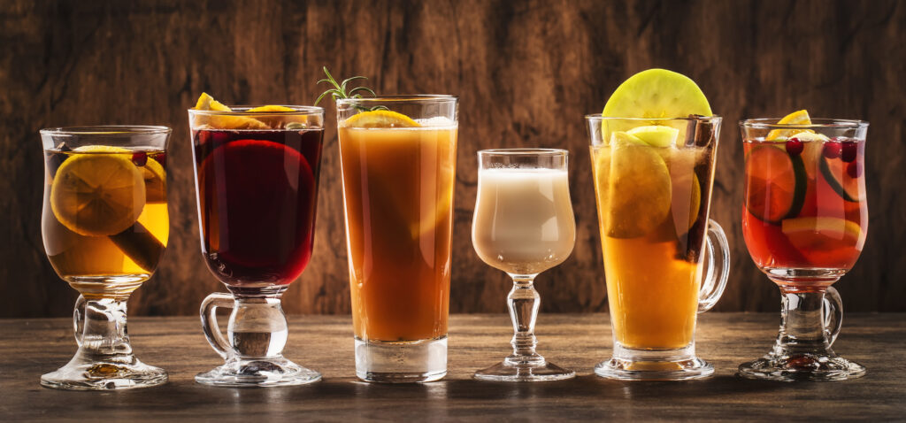 various sizes of glasses containing different fall colors of drinks