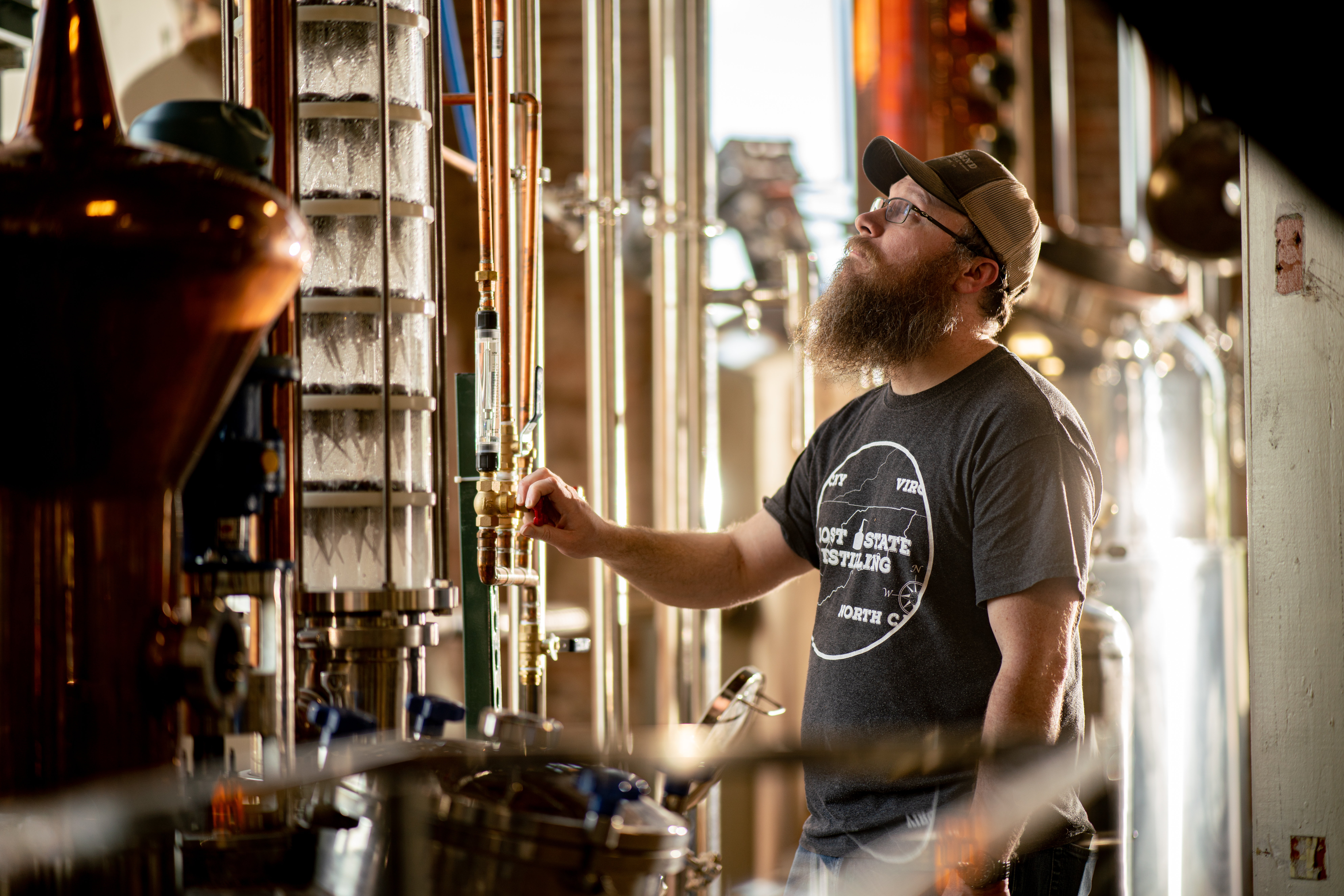 one of the owners looking at the still in lost state distilling